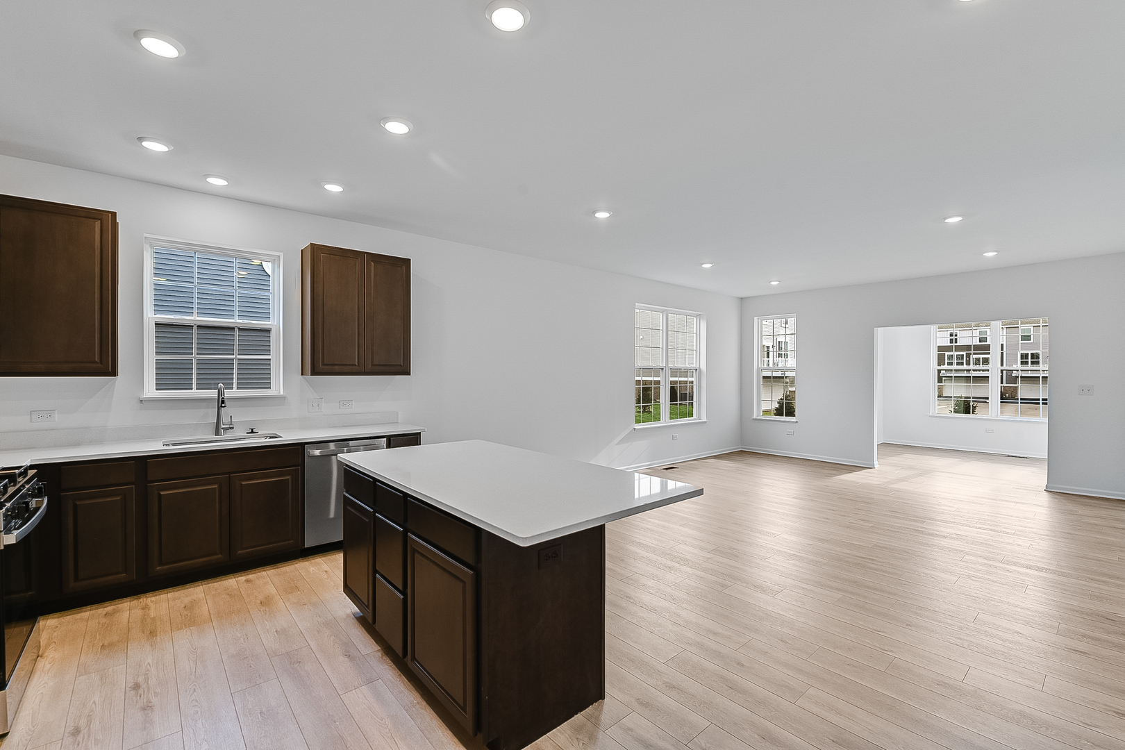14905 South Mccarthy Circle Plainfield, IL 60544 - Photo 6 of 13 a kitchen with stainless steel appliances granite countertop a stove a sink dishwasher a microwave oven and a dining table with wooden floor