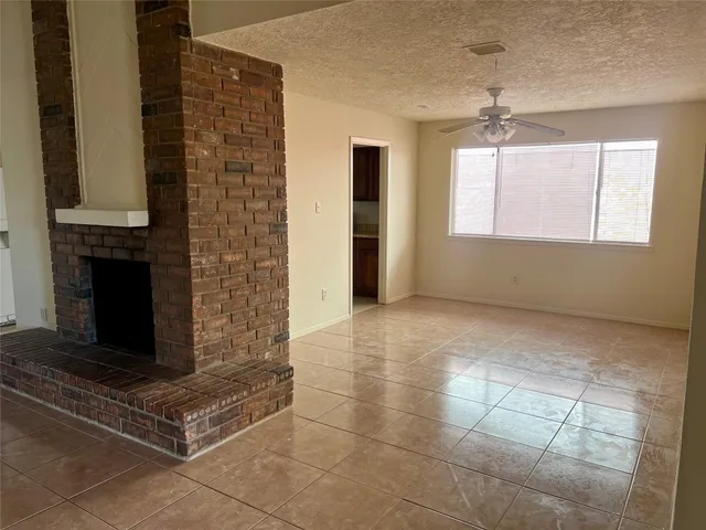 a view of an empty room with a fireplace and a window