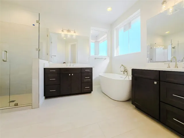 a spacious bathroom with a tub sink shower and mirror