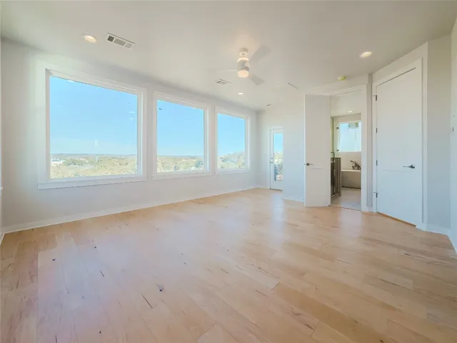 a view of a hallway with stairs and wooden floor