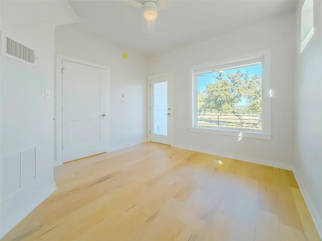 a view of empty room with wooden floor