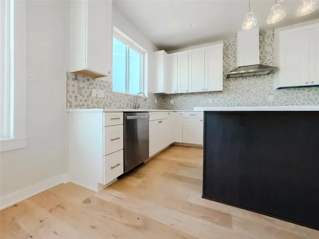 a kitchen with granite countertop a sink cabinets and a wooden floor