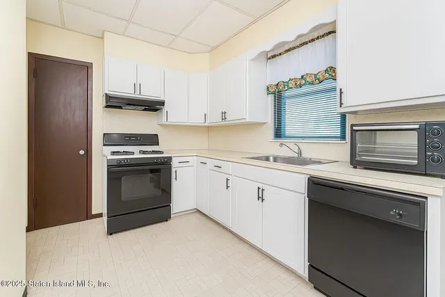 a kitchen with cabinets appliances and a window