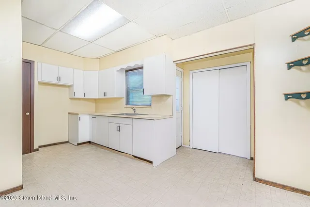 a large white kitchen with cabinets