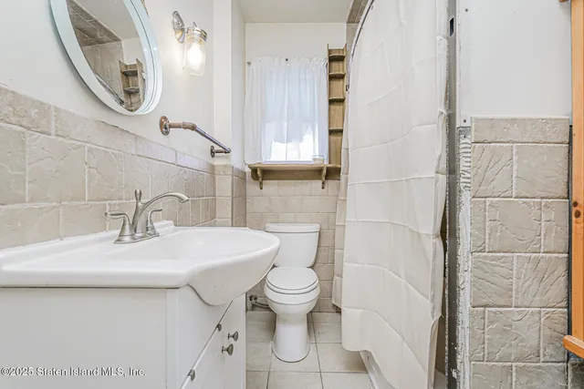 a bathroom with a sink toilet and a mirror