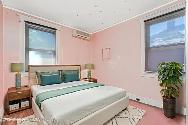 a bedroom with a bed and a potted plant