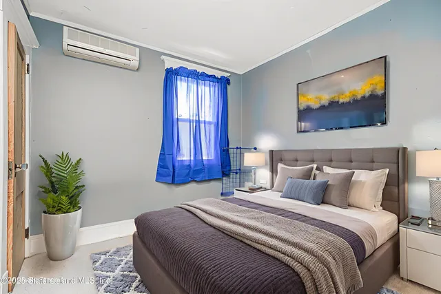 a bedroom with a bed and a potted plant