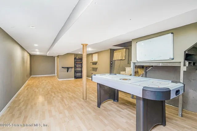 a room with a table chairs window and wooden floor
