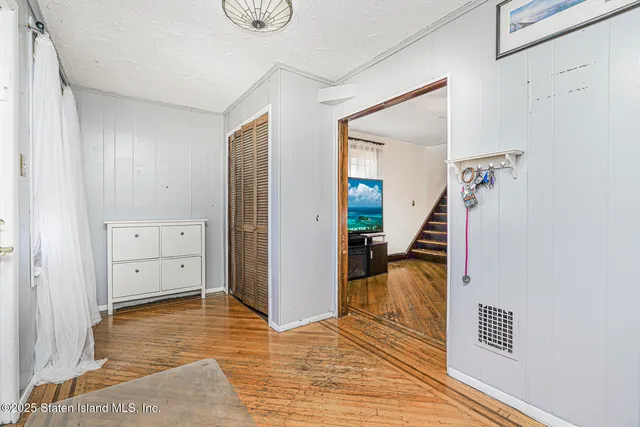 a view of a hallway with wooden floor and closet