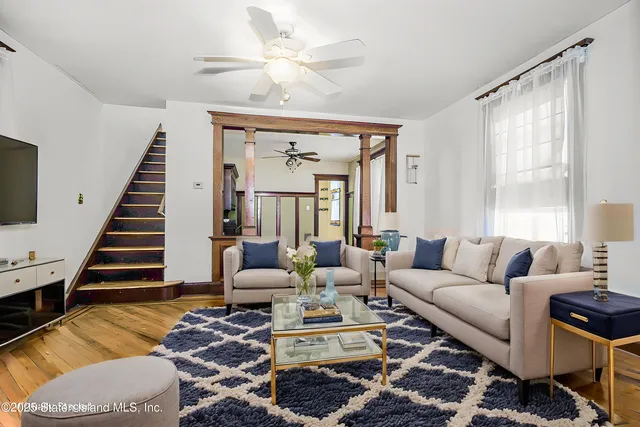 a living room with furniture ceiling fan and a window