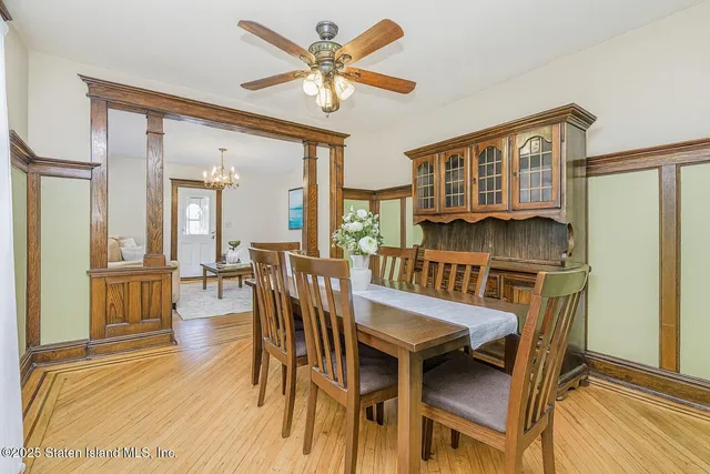a dining room with furniture a rug a flat screen tv and a large window