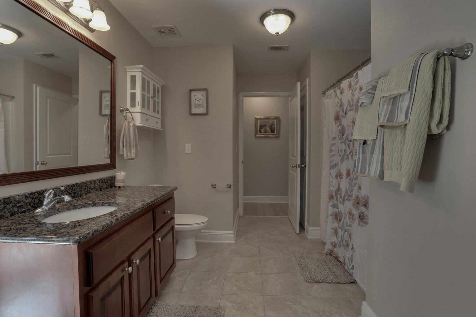 136 Leonine Hollow Crestview, FL 32536 - Photo 18 of 27 a bathroom with a granite countertop sink a toilet and shower