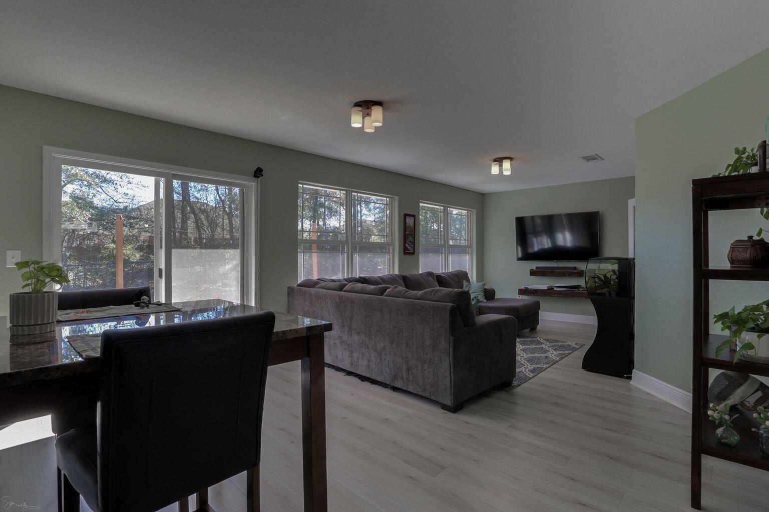 136 Leonine Hollow Crestview, FL 32536 - Photo 25 of 27 a living room with furniture a flat screen tv and large windows
