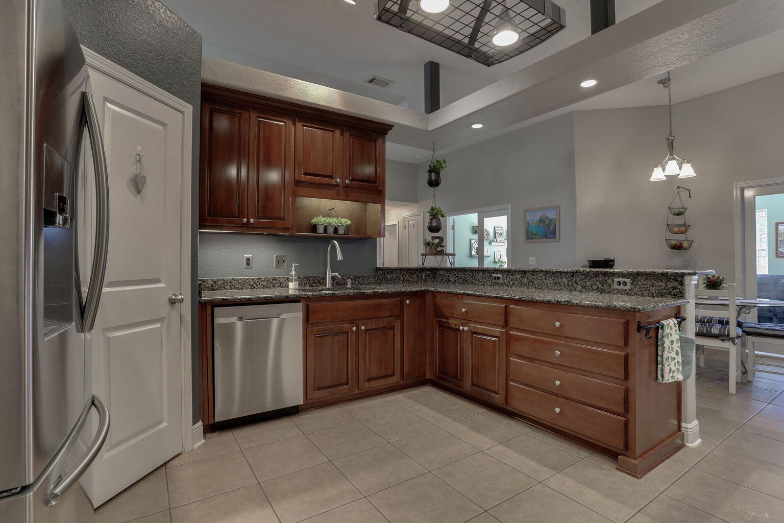 136 Leonine Hollow Crestview, FL 32536 - Photo 8 of 27 a kitchen with granite countertop a refrigerator and cabinets