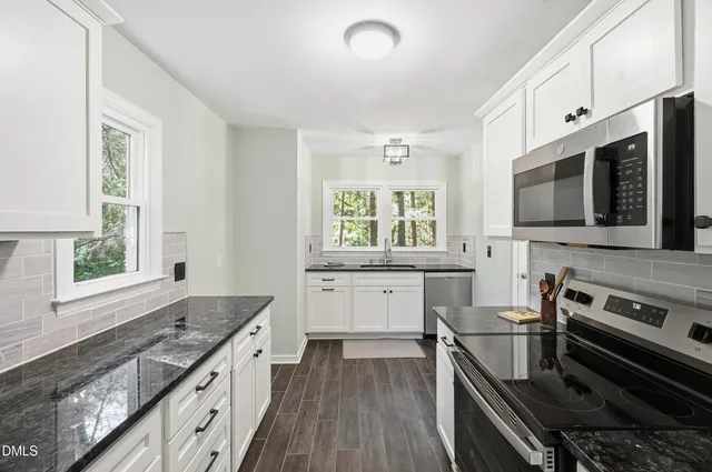 a kitchen with a stove a sink and a microwave