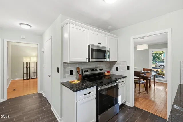 a kitchen with granite countertop a stove a sink and a refrigerator