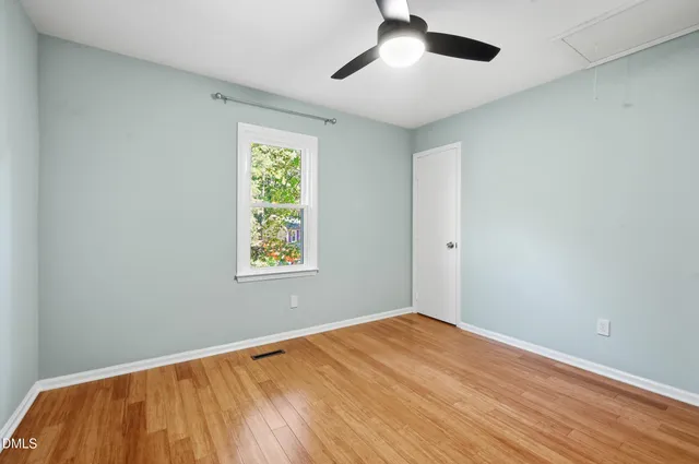 a view of empty room with wooden floor