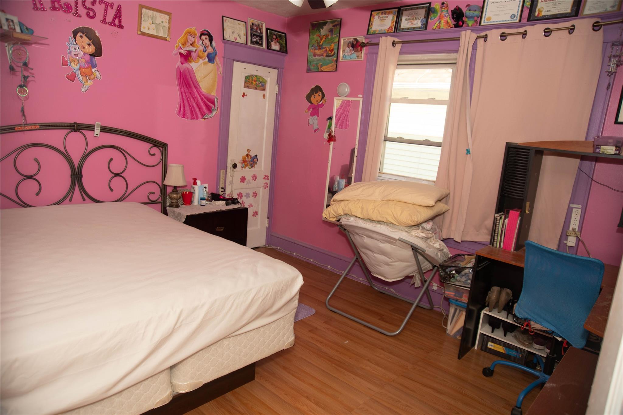135-40 Alwick Road Queens, NY 11420 - Photo 19 of 38 a bedroom with a bed and a table in it with wooden floor