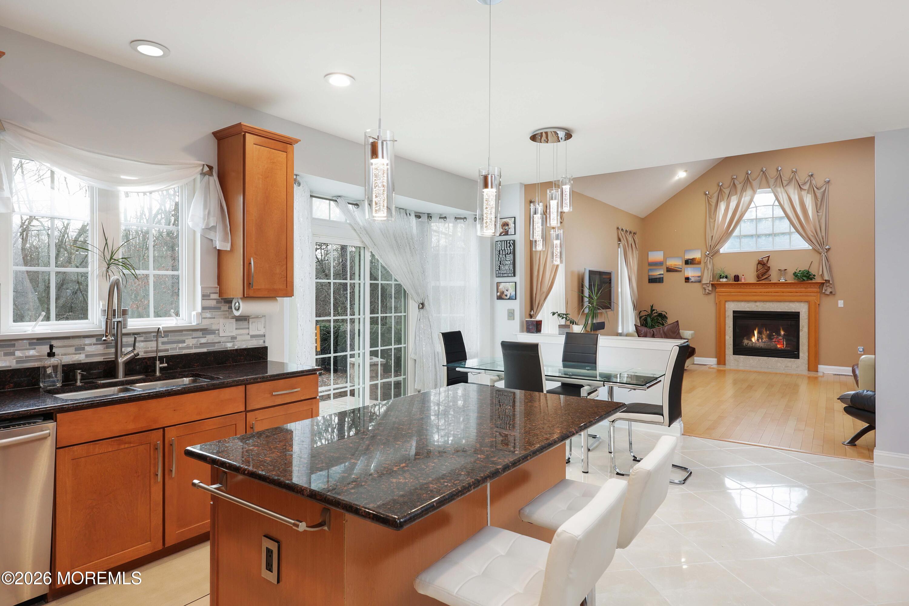 14 Emily Road Manalapan, NJ 07726 - Photo 12 of 44 a dining hall with stainless steel appliances granite countertop a sink dishwasher and a flat tv screen next to a large window
