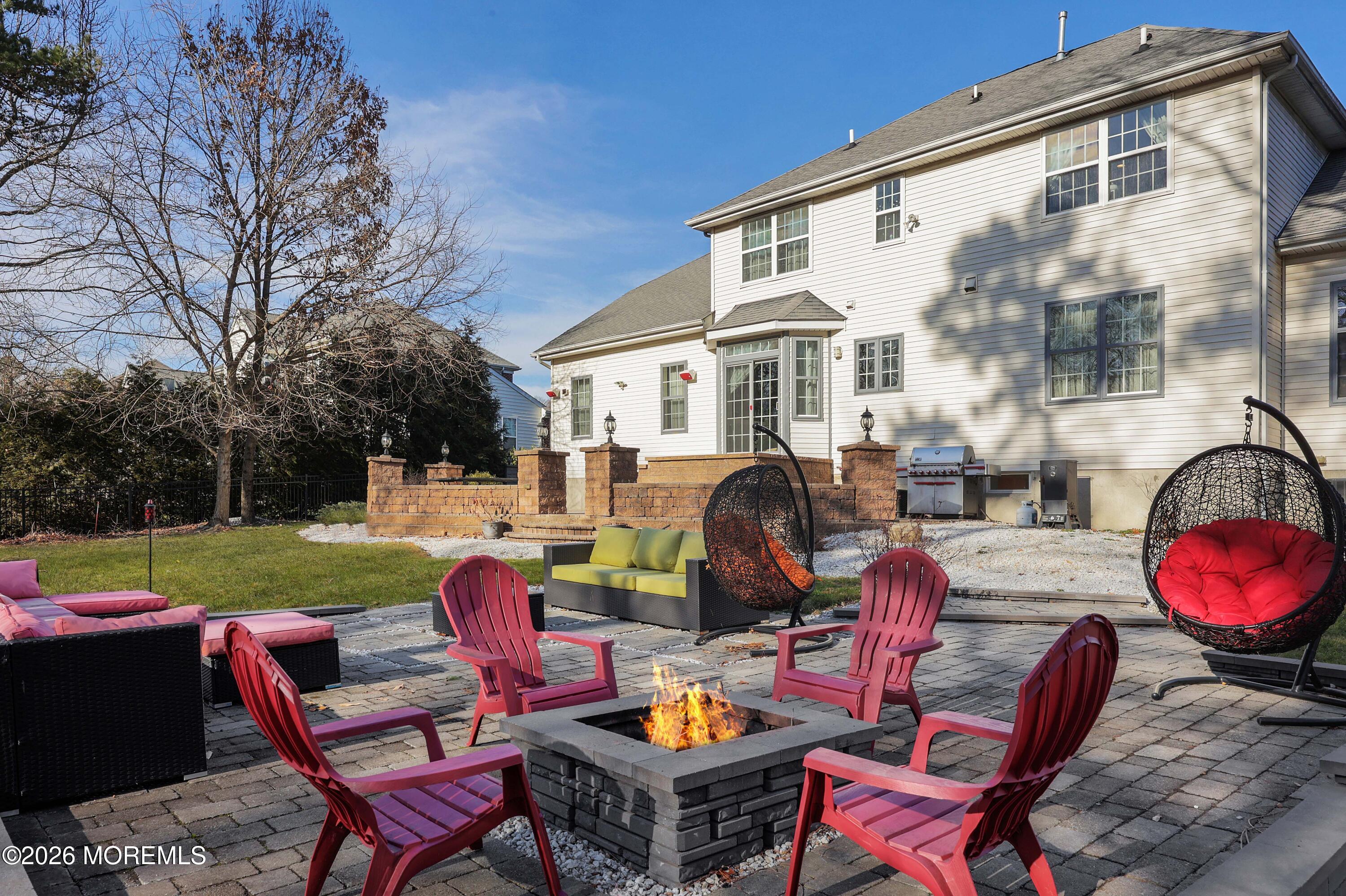 14 Emily Road Manalapan, NJ 07726 - Photo 25 of 44 a view of a patio with couches table and chairs under an umbrella