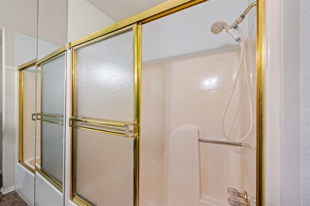 6605 Bluebonnet Drive Rowlett, TX 75089 - Photo 17 of 25 a bathroom with a glass shower door