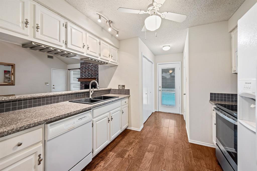 6605 Bluebonnet Drive Rowlett, TX 75089 - Photo 7 of 25 a kitchen with granite countertop a stove a sink and a refrigerator