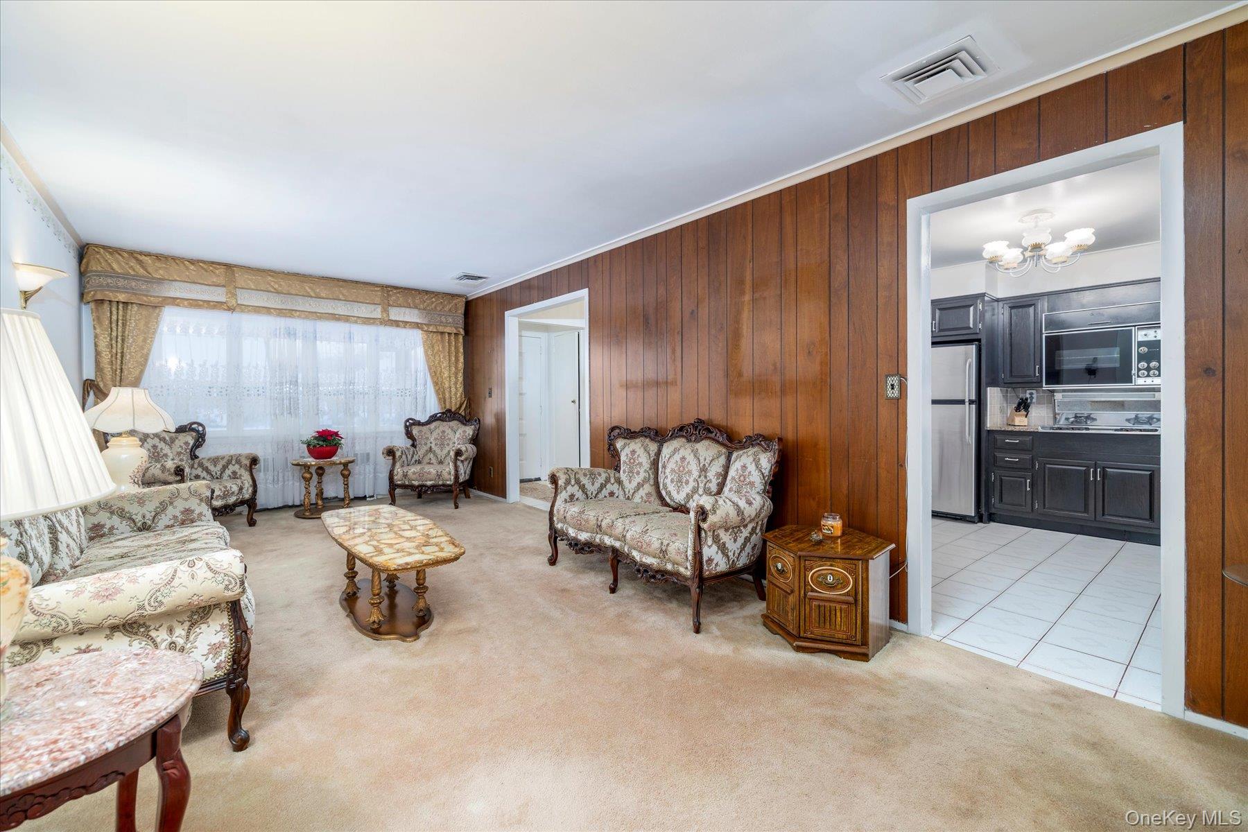 2934 Kinloch Road Wantagh, NY 11793 - Photo 5 of 30 Living area with light carpet, light tile patterned flooring, and crown molding