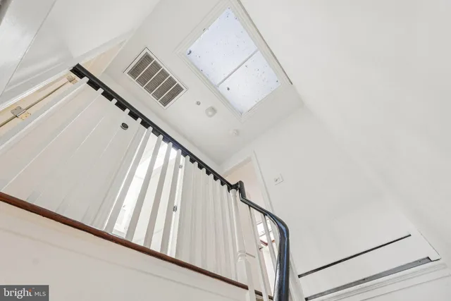 a view of staircase with railing and white walls