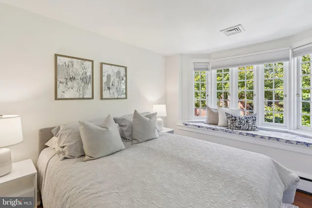 a bedroom with a bed and a large window