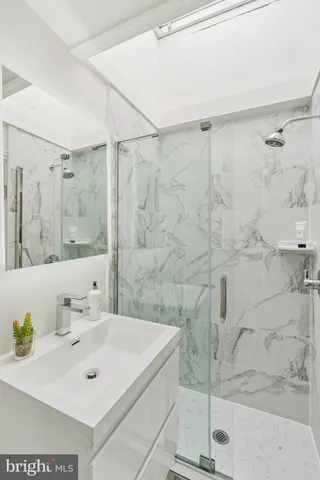 a bathroom with a sink shower and a mirror