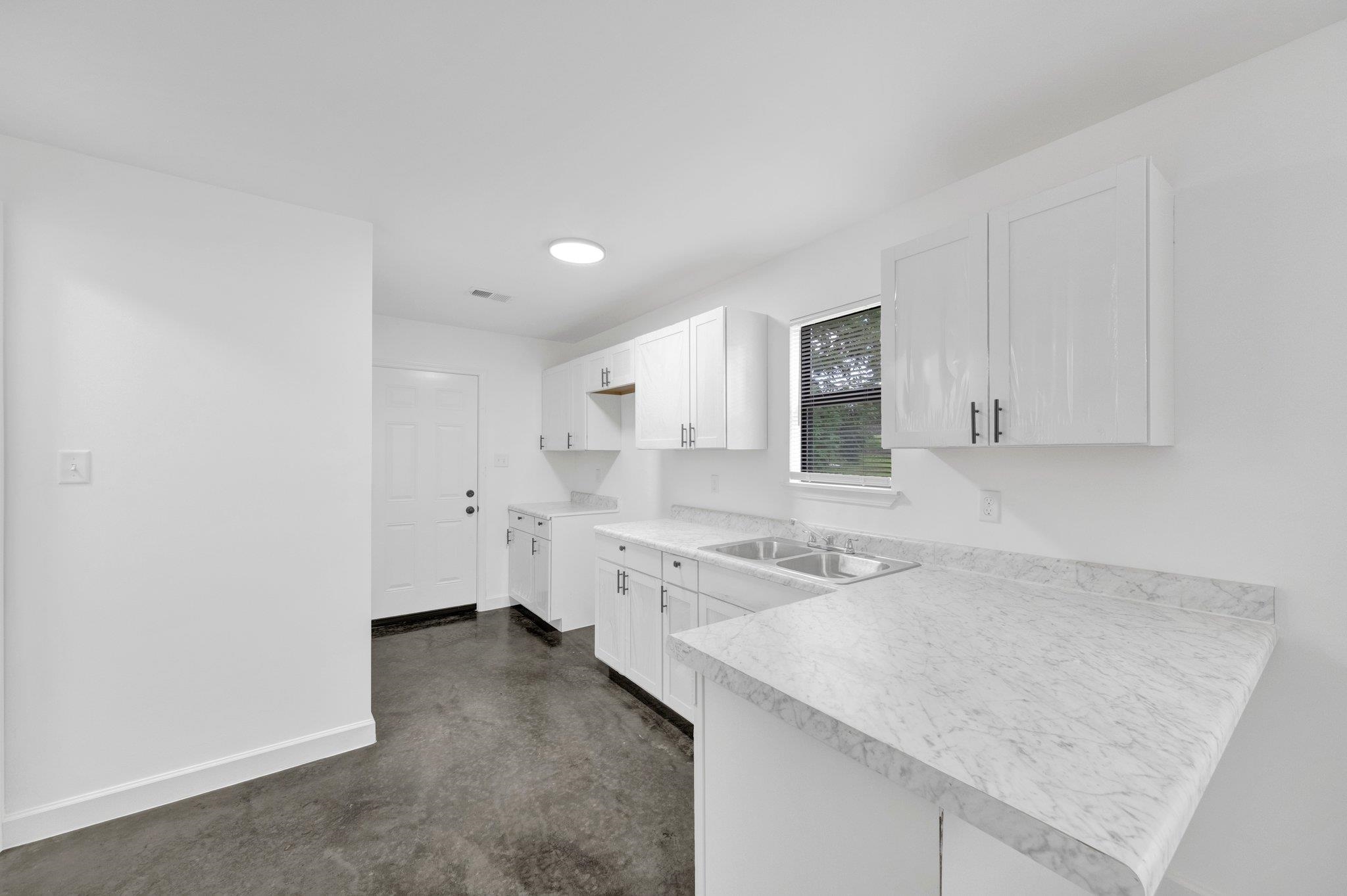 653 Gilleas Road Memphis, TN 38109 - Photo 12 of 24 a kitchen with a sink dishwasher and a stove with wooden floor