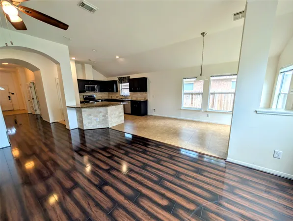 en empty room with windows and ceiling fan