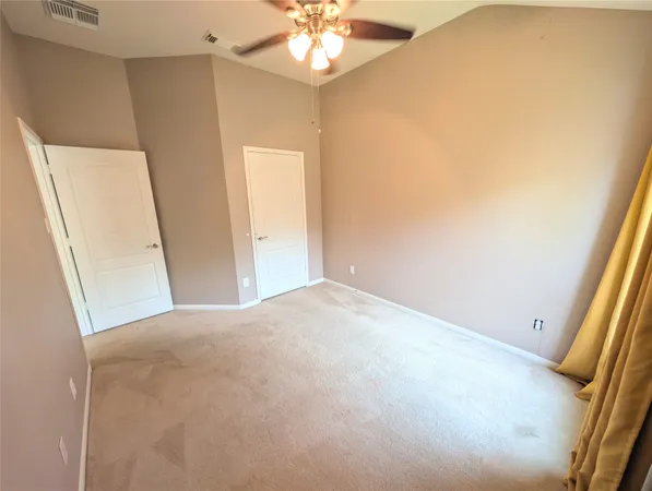 an empty room with a window and a fan