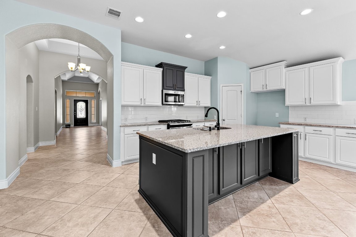 217 Serrano Street Georgetown, TX 78628 - Photo 11 of 27 a kitchen with granite countertop a sink and cabinets