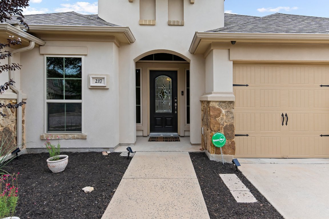 217 Serrano Street Georgetown, TX 78628 - Photo 2 of 27 a front view of a house with a garden