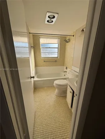 a bathroom with a sink a toilet a tub and shower