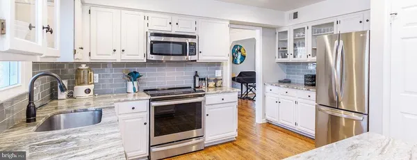 a kitchen with stainless steel appliances granite countertop a refrigerator sink and stove