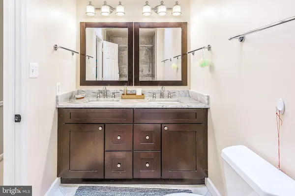 a bathroom with a sink vanity mirror and toilet