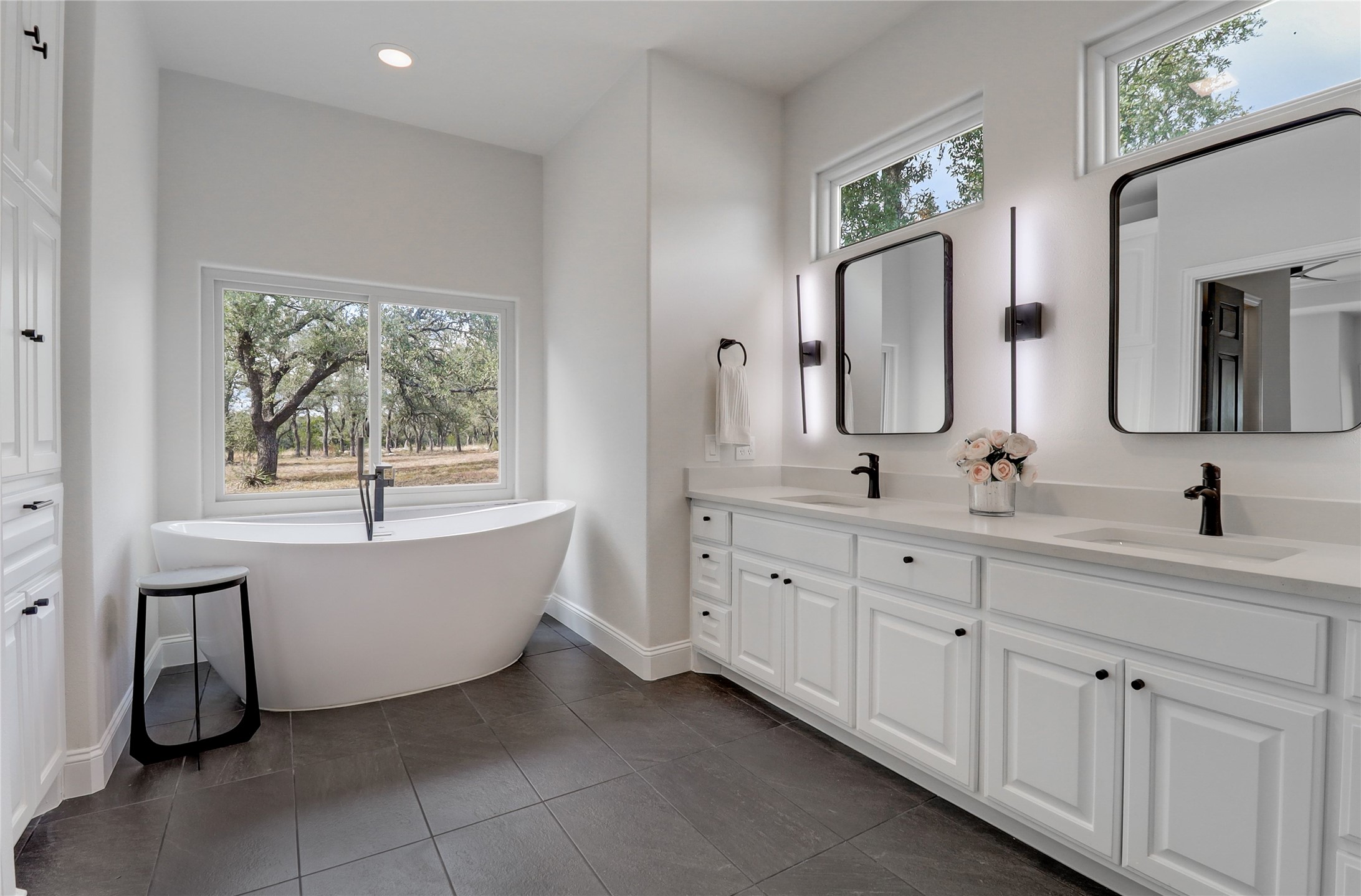 1100 Norwood Road Dripping Springs, TX 78620 - Photo 17 of 38 a bathroom with a double vanity sink a mirror and a bathtub