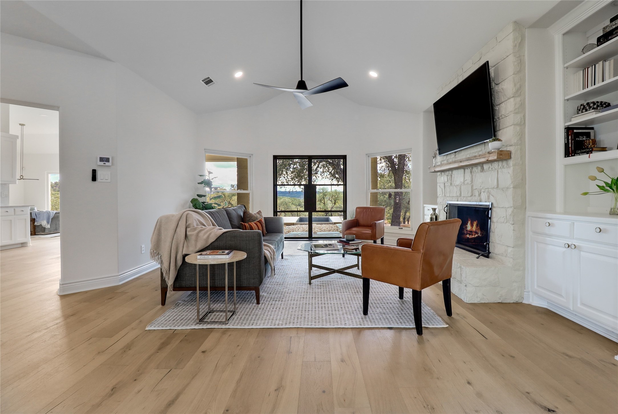 1100 Norwood Road Dripping Springs, TX 78620 - Photo 3 of 38 a living room with fireplace furniture and a flat screen tv