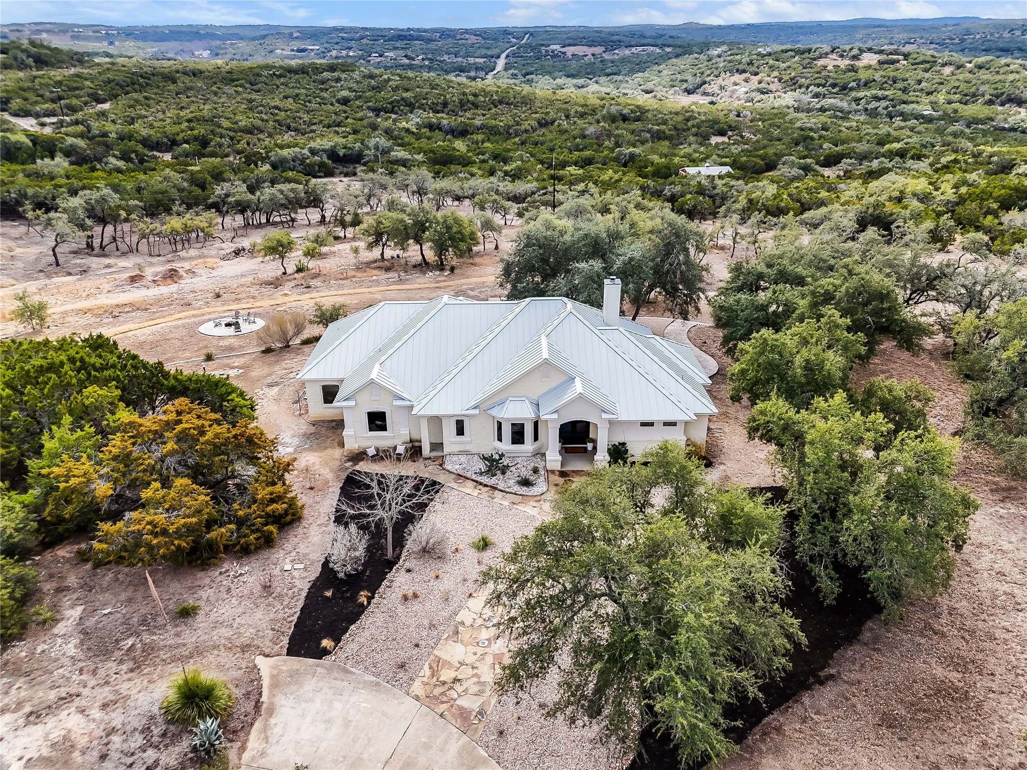 1100 Norwood Road Dripping Springs, TX 78620 - Photo 33 of 38 an aerial view of a house with a yard wooden table and chairs