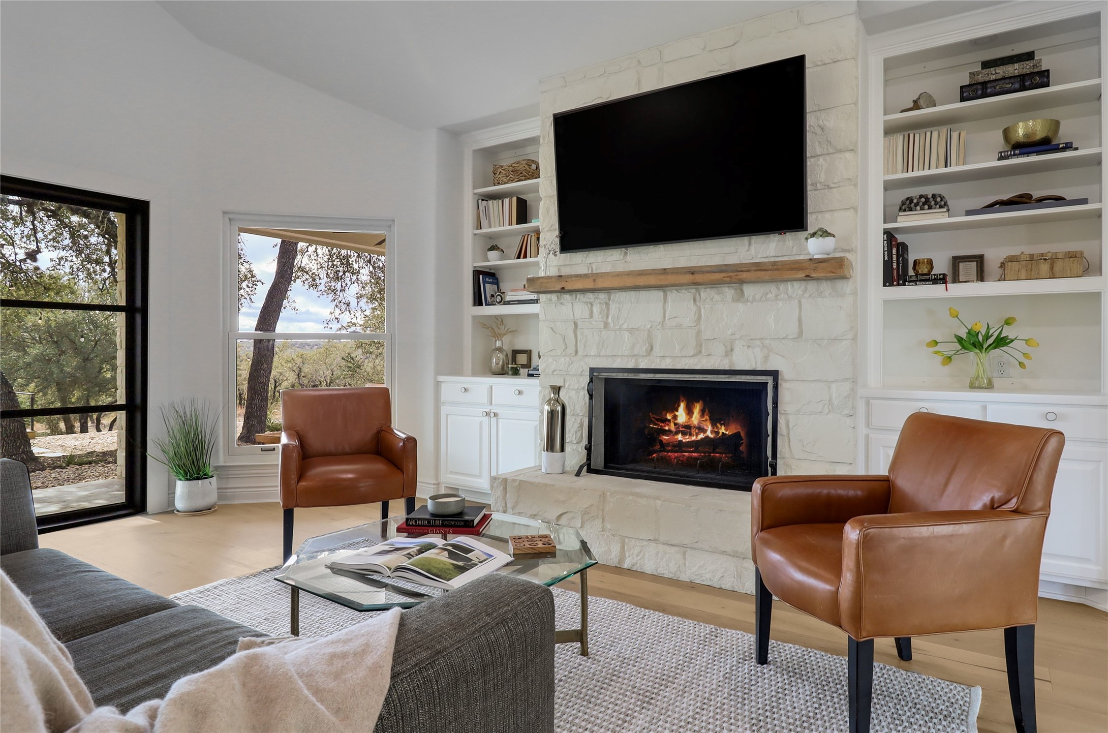 1100 Norwood Road Dripping Springs, TX 78620 - Photo 4 of 38 a living room with furniture a flat screen tv and a fireplace
