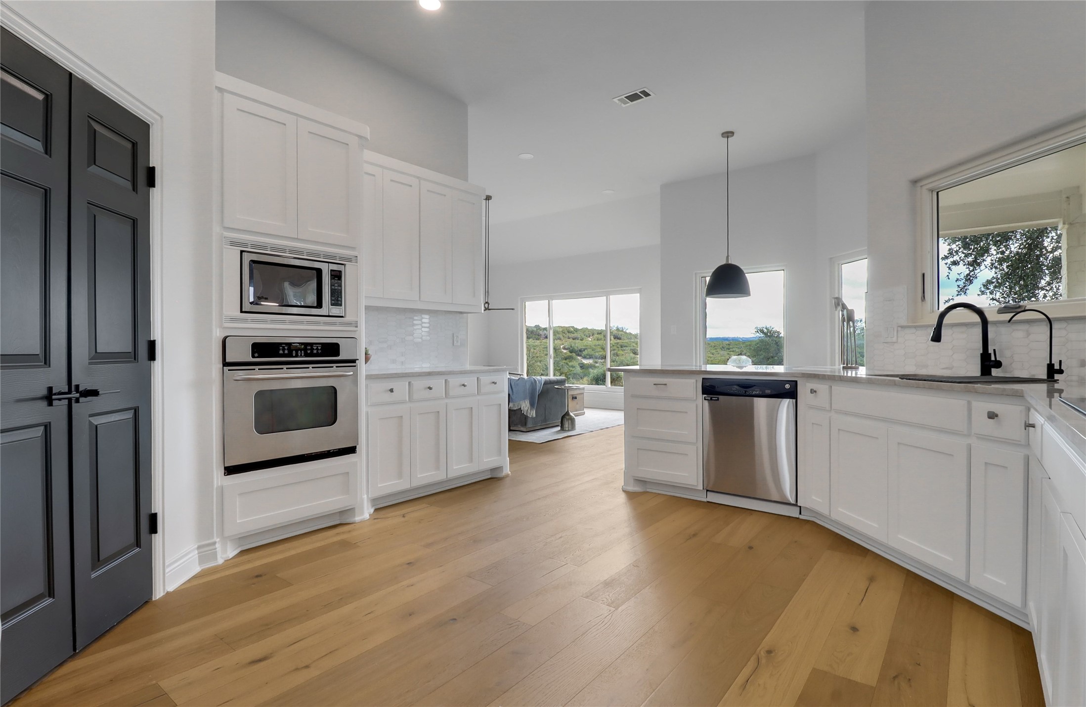 1100 Norwood Road Dripping Springs, TX 78620 - Photo 5 of 38 a kitchen with a refrigerator sink and white cabinets