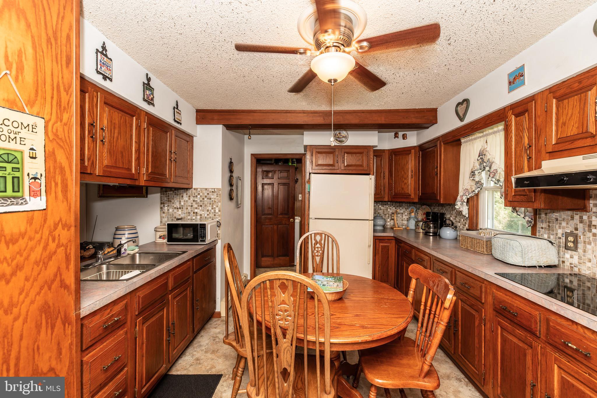 9516 Highland Street Mauricetown, NJ 08329 - Photo 18 of 53 a kitchen with stainless steel appliances kitchen island granite countertop a sink a stove cabinets dining table and chairs