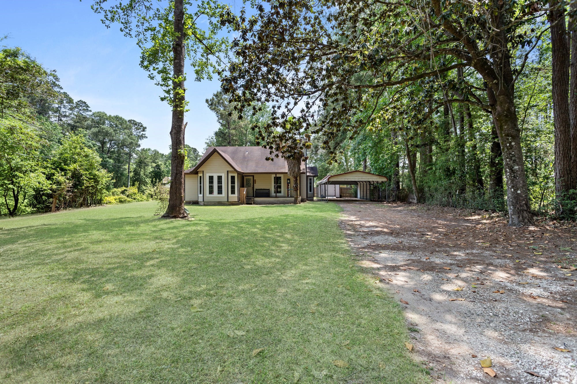 a front view of a house with a yard and trees