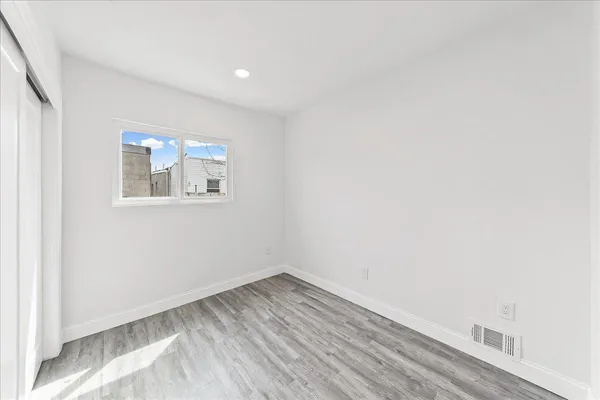 a view of an empty room with wooden floor