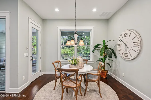 a dining room with furniture a kitchen and chandelier