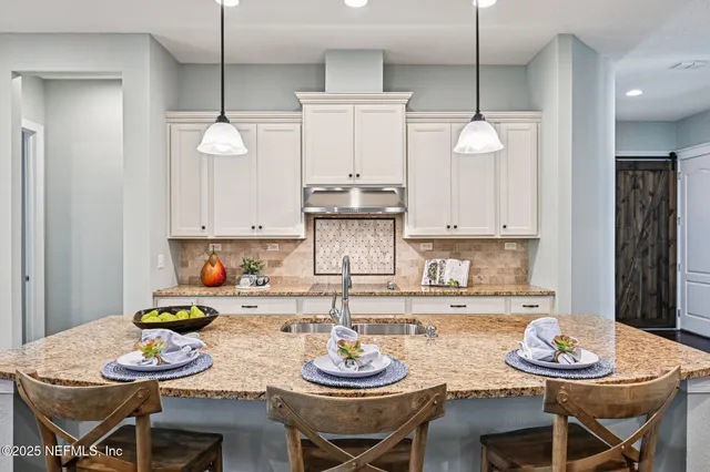 a kitchen with stainless steel appliances granite countertop white cabinets sink and dishwasher