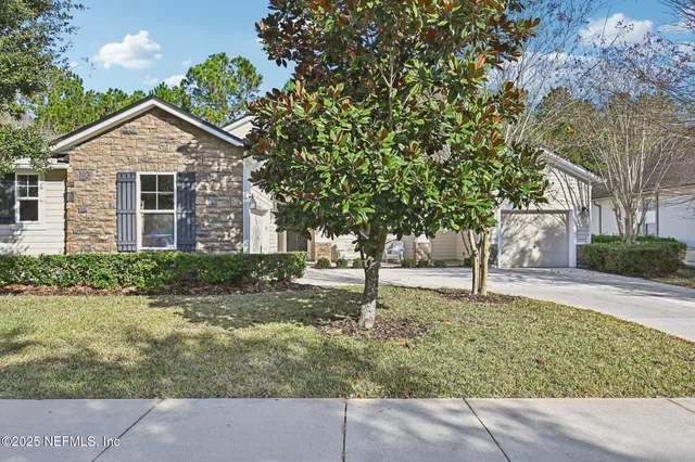 a front view of house with yard and trees around