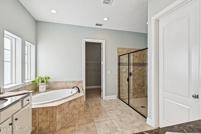 a large white bathroom with a granite countertop sink mirror and bathtub